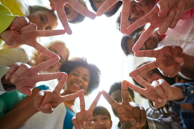 Group of diverse teens making a shape with their hands